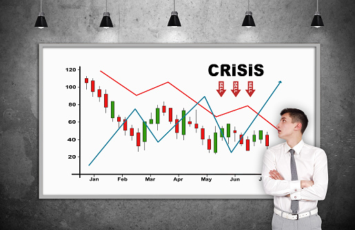 Businessman standing in room and looking on billboard with drawing crash chart. Business and financial crisis concept.