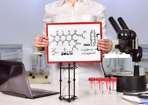 Medical researcher woman holding clipboard with drawing chemical scheme. Science and healthy lifestyle concept.