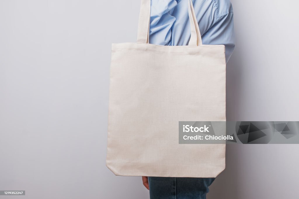 Woman holding blank cotton eco tote bag Woman holding blank cotton eco tote bag, design mockup. Bag Stock Photo