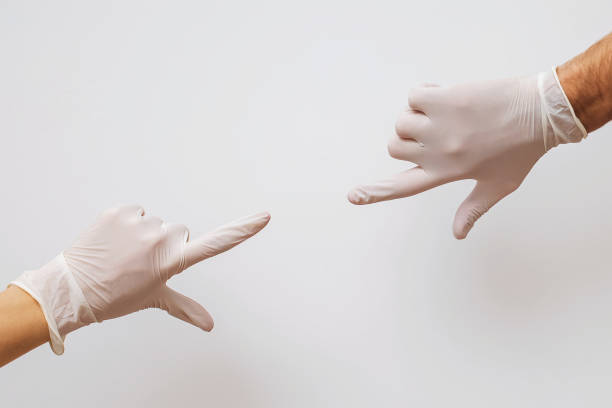 istock Two hands covered with rubber gloves reaching towards each other 1219352336