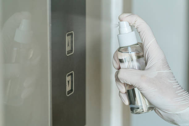 closeup asian woman hand wearing medical gloves and spraying anti-bacterial sanitizer spray to the elevator button before cleaning press, coronavirus network outbreak - hand sanitizer liquid soap hygiene healthy lifestyle imagens e fotografias de stock