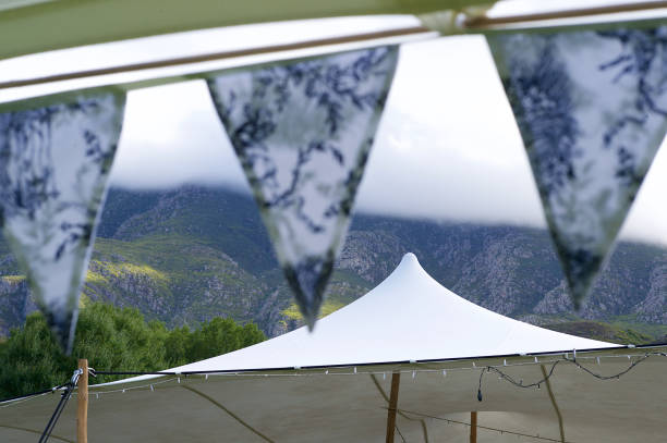 istock Bunting Marquee Tent and Cloud covered Mountains with string lights 1219355433