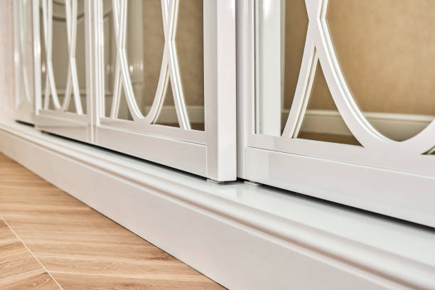 istock Sliding mirror wardrobe doors with overlays decor. White sliding mirror wardrobe on parquet background 1219355850