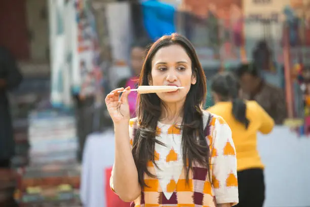 One women eating ice cream at street market
