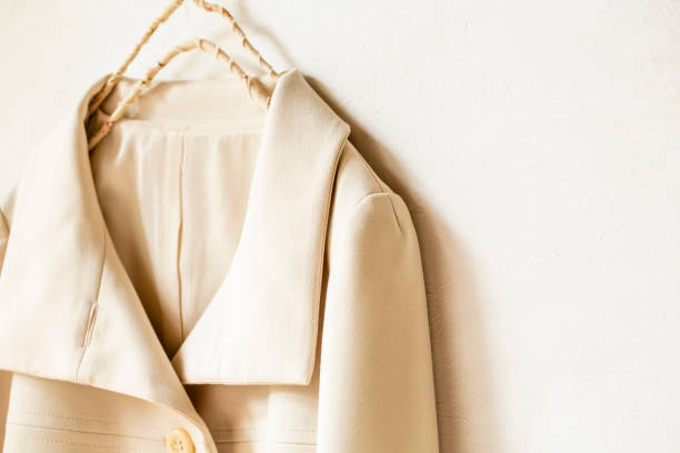 istock beige or white jacket hanging on clothes hanger on white background. 1219357721
