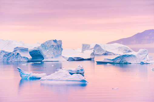 Blue icebergs in Atlantic ocean at sunset. Saqqaq village, west coast of Greenland