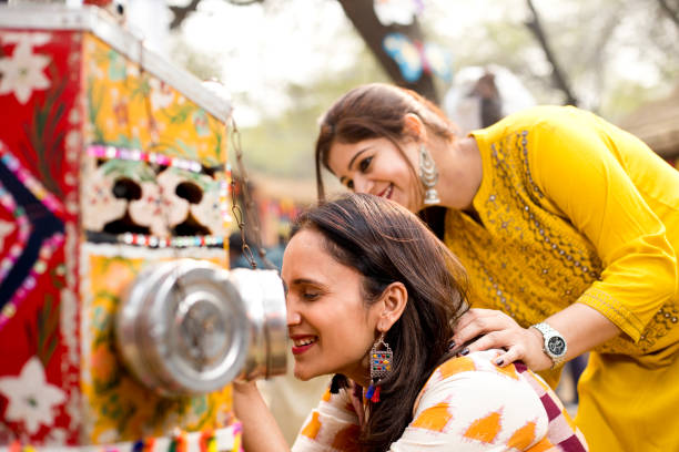 istock Women looking into bioscope at Surajkund Mela 1219361329
