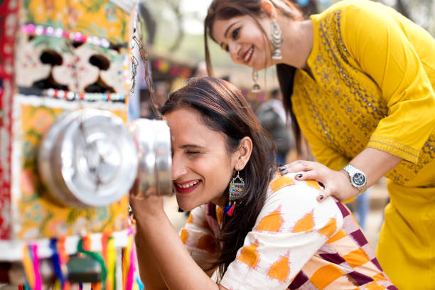 istock Women looking into bioscope at Surajkund Mela 1219361377