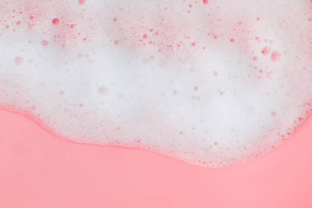 istock White soap foam on pink background 1219362151