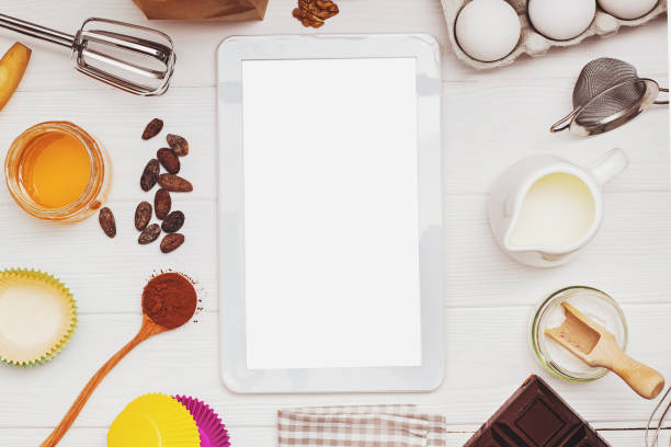 istock Ingredients and tools for baking and tablet with blank screen and place for text or image on white table 1219362214