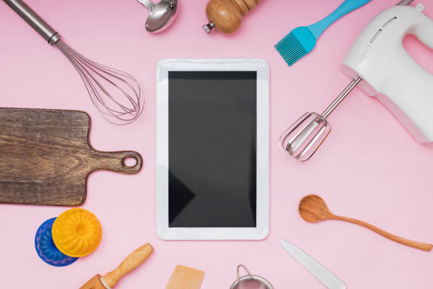 istock Tools for baking and cooking tablet with blank screen and place for text or image on pink background 1219362255