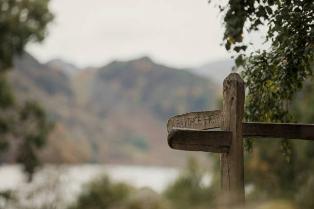 Wooden signpost is in focus with Place Fell out of focus in the background
