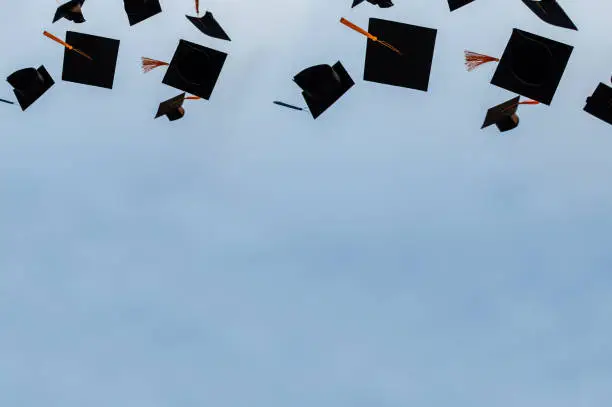 Graduation hat Thrown in the Air with bluesky abstract background.