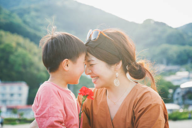 istock Boy handing mother a carnation flower 1219363046