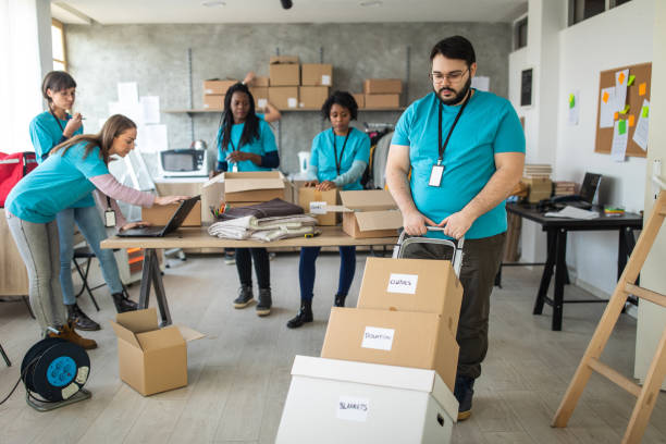 istock Overweight man pushing push cart with cardboard boxes with humanitarian aid 1219364307