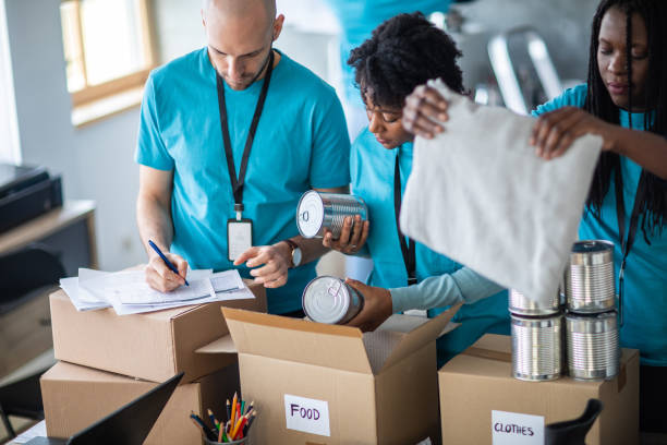 istock Volunteers checking and packing donation boxes at charitable foundation 1219364750