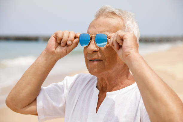 istock Happy senior man walking on the beach 1219364880