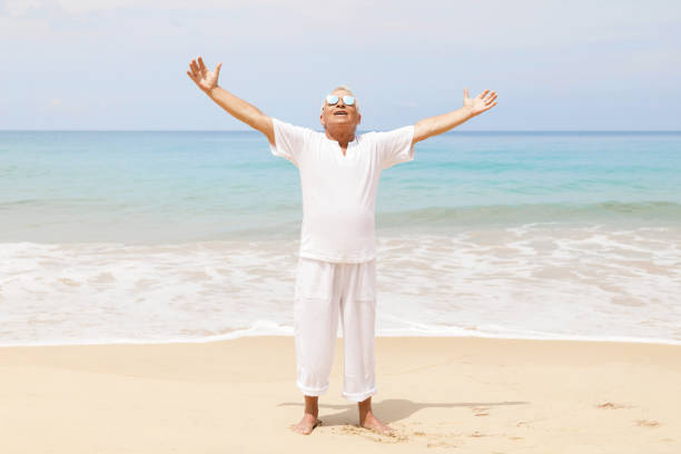 istock Happy senior man walking on the beach 1219365114