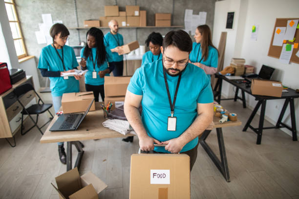 istock Overweight man pushing push cart with cardboard boxes with humanitarian aid 1219365769