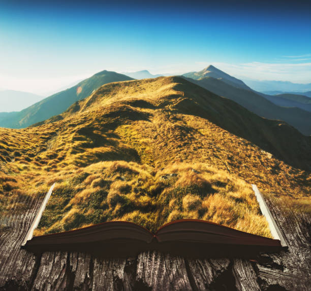 istock Mountain valley covered with grass on the pages of an open magical book 1219366815