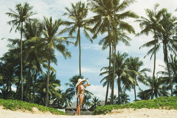 istock Beautiful woman on the beach with a palm trees 1219367188