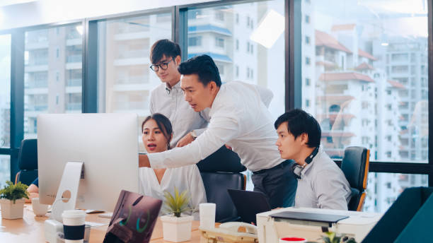 empresarios que utilizan la presentación por computadora y la comunicación que reunionen ideas de lluvia de ideas sobre colegas de proyecto estrategia de éxito plan de trabajo en la oficina moderna. - asiático de asia sudoriental fotografías e imágenes de stock