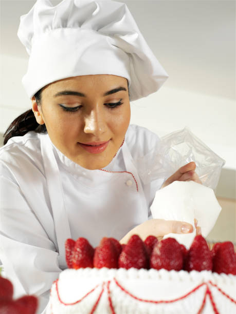 istock Female Chef Working On Strawberry Cake 1219368971
