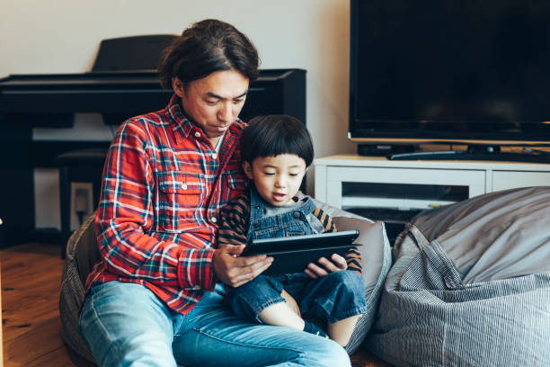 istock Father and son using tablet at home together 1219371031