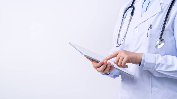 태블릿을 들고 흰색 코트에 청진기와 의사, 의료 정보를 보여주는, 진단, 흰색 배경에 고립. - ipad women human hand digital tablet 뉴스 사진 이미지