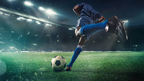 calciatore o calciatore in azione sullo stadio con torce, palla da calcio per gol vincente, grandangolo. azione, concorrenza in movimento - calciare foto e immagini stock