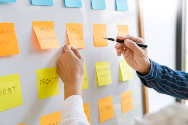 istock young business workers posting with sticky notes stickers reminders  creative brainstorming at board the colleague in a modern co-working space 1219374162