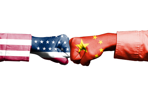 USA and China flag print screen on fist hand on white background. Its is symbol for tariff trade war crisis between United States of America and China which the biggest economic country in the world.