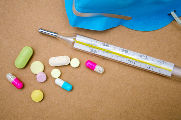 tabletki i termometr na stole - nutritional supplement flash zdjęcia i obrazy z banku zdjęć