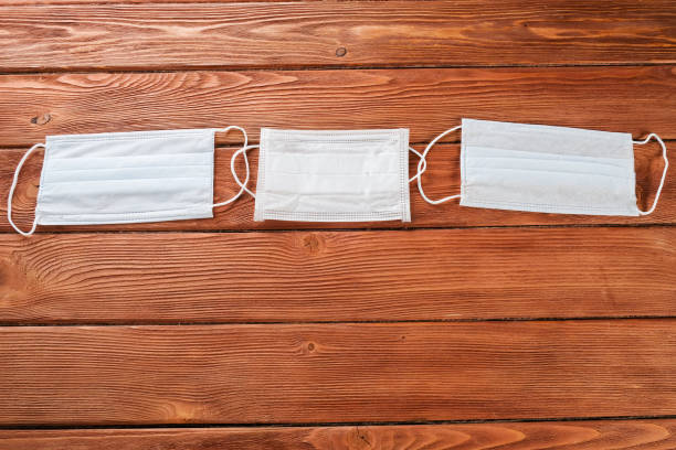 istock Medical masks on a wooden table. 1219375792