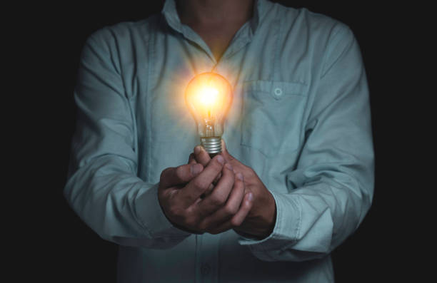 istock Businessman holding lightbulb which it glowing on black background and copy space .Creativity idea concept. 1219375939