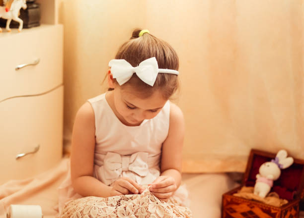 istock little girl is engaged in sewing at home, needlework 1219376076