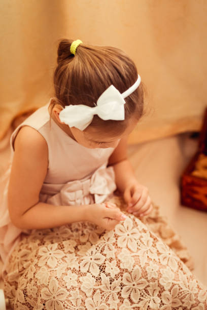istock little girl is engaged in sewing at home, needlework 1219376077