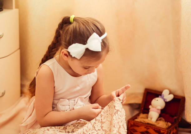 istock little girl is engaged in sewing at home, needlework 1219376093