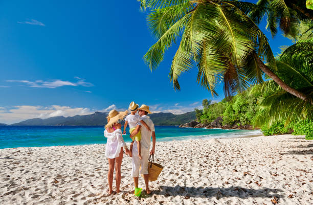Family with three year old boy on beach. Seychelles, Mahe. Family on beautiful Anse Soleil beach, young couple in white with three year old toddler boy. Summer vacation at Seychelles, Mahe. mahe island stock pictures, royalty-free photos & images