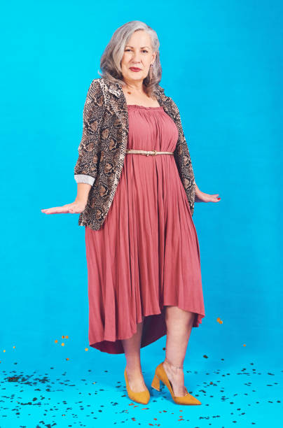Full length shot of a funky and stylish senior woman posing in studio against a blue background
