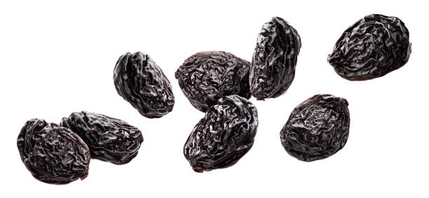 Prunes isolated on white background with clipping path Falling prunes isolated on white background with clipping path, dried plums collection prune stock pictures, royalty-free photos & images