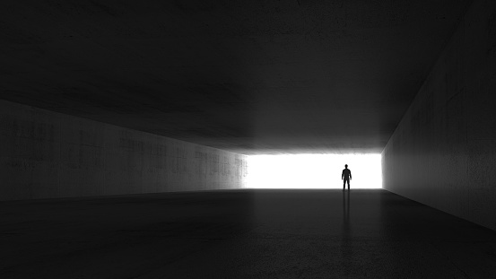 A man standing in the end of an empty dark concrete corridor, 3d rendering illustration
