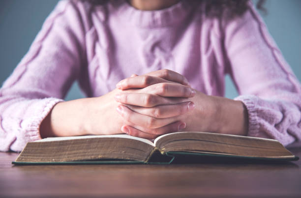 istock prayer woman hand Bible 1219384559