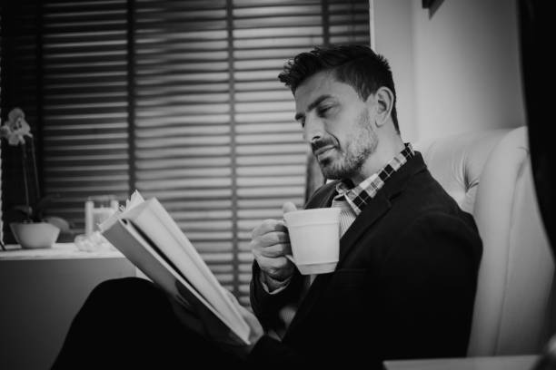 istock Caucasian Man Enjoying Coffee and Reading a Book 1219386196