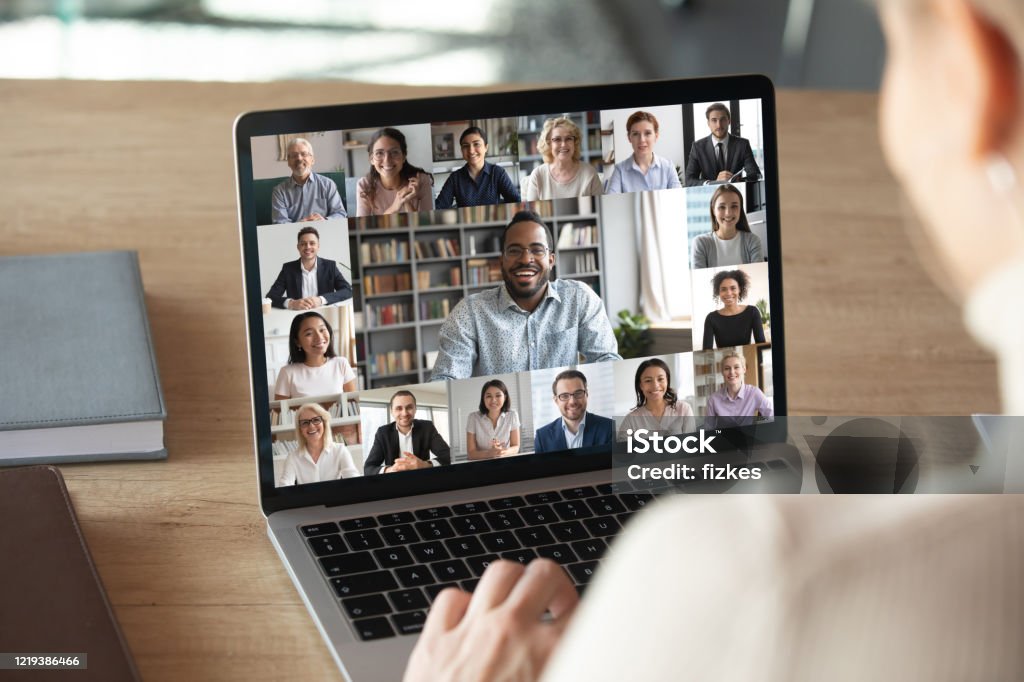 Female employee talk on video call with colleagues Back view of female employee speak talk on video call with diverse multiracial colleagues on online briefing, woman worker have Webcam group conference with coworkers on modern laptop at home Meeting Stock Photo