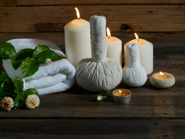 istock Spa herbal compressing ball with alight scented candles on wooden background. 1219387461