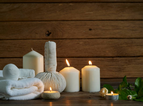 istock Spa herbal compressing ball with alight scented candles on wooden background. 1219387464