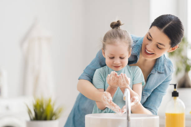 mädchen und ihre mutter waschen hände - mirror mother bathroom daughter stock-fotos und bilder