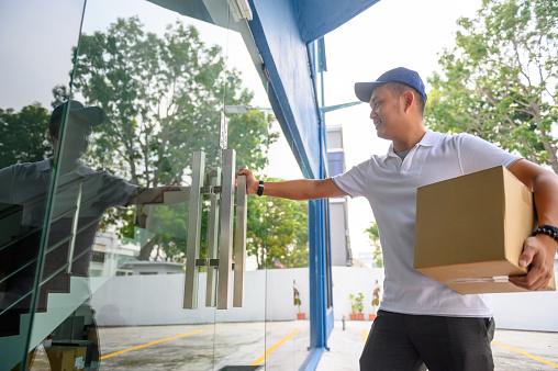 Delivery man holding a cardboard box to shipped