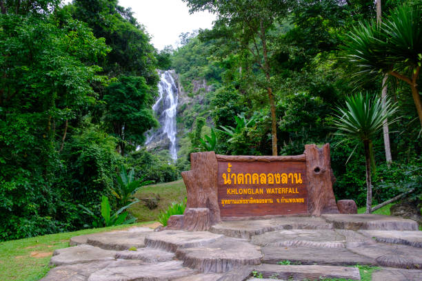 istock Beautiful waterfall stream with a man standing at Khlong-Lan National Park, Thailand. Translation: 